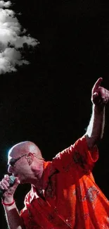 Dynamic singer in red shirt performing energetically on stage.