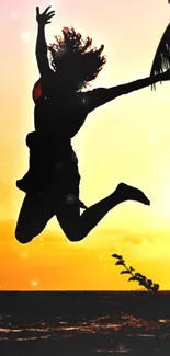 Silhouette jumping against a vibrant sunset beach background.