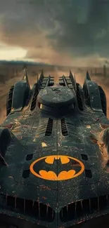 Epic Batmobile with stormy backdrop on mobile wallpaper.