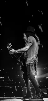 Black and white wallpaper of guitarist on stage.