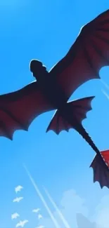 Silhouette of a dragon flying over mountains in a bright blue sky.