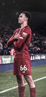 Footballer in red jersey posing on field during a game.