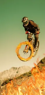 Biker jumps through flames in a stunning mountain panorama.