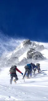 Climbers ascend a snowy mountain peak under a blue sky.