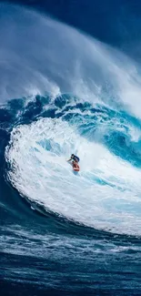 Surfer riding a massive ocean wave in stunning blue colors.