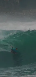 Surfer riding a huge teal wave in an exhilarating moment.