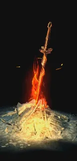 Sword standing in a fiery bonfire on a dark background.