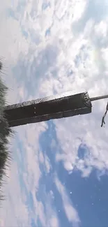 Epic sword under a bright blue sky with clouds.