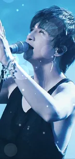 Singer performing with blue lighting in a concert wallpaper.