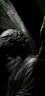 Ethereal dark angel sculpture with wings in black tones.