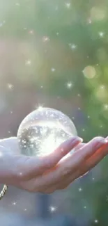 Hand holding a crystal sphere with sparkles and a mystical effect.