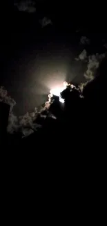 Moonlit cloud silhouette against night sky.