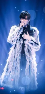 Singer in blue lighting on stage creating an ethereal and captivating visual moment.