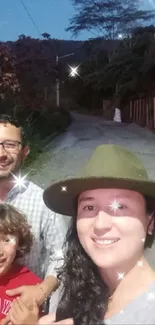 Family enjoying an evening walk on a scenic road under a blue sky.