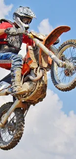 Motocross rider performing a mid-air jump with a sky backdrop.