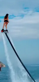 Woman on a water jetpack soaring high above the ocean.