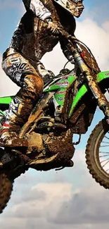 Dynamic motocross rider jumping high on a dirt bike against a cloudy sky.