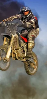 Motocross rider performing a high-flying jump with a dramatic dust cloud in the background.