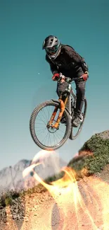 Mountain biker airborne on rocky trail with flames overlay.