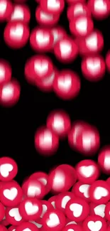 Mobile wallpaper of falling red hearts with bokeh effect on black background.