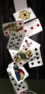 Falling playing cards on a dark wooden background.