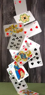 Playing cards cascading against wooden background.