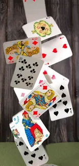 Playing cards tumbling on wooden background.