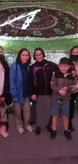 Family posing by a scenic flower clock.