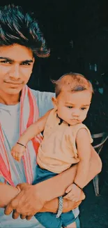 A young man holding a child in earthy tones, displaying family warmth.