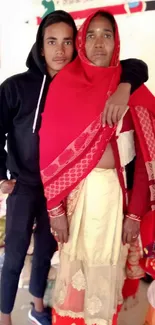 Mother and son embracing in vibrant red attire.