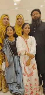 Family in traditional festive attire, smiling.