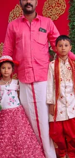 Family in traditional festive attire with vibrant red background.