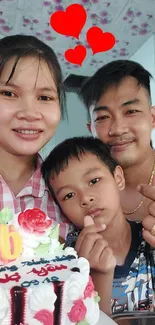 Smiling family celebrating with cake and heart decorations.