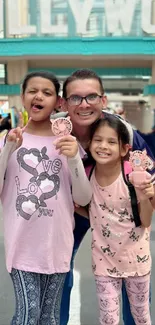 A family enjoying a theme park day with bright pink outfits.