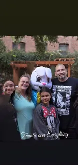 Smiling family with a mascot under trees.