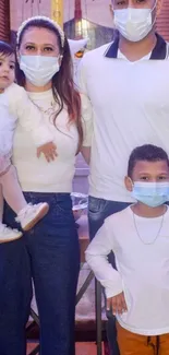 Family wearing white clothes and masks posing indoors.