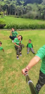 Family taking selfie in green park setting, wearing casual clothes.