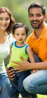 Happy family sitting on green grass in a sunny park.