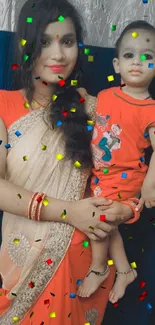 Mother holding child in red attire, smiling warmly.