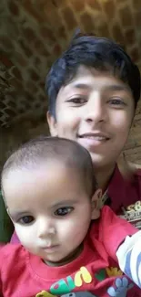 Smile with baby in front of a brick wall.