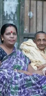 Family sitting on a rustic porch in traditional attire, showcasing cultural warmth.