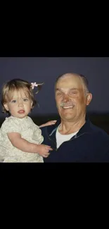 Father holding child during tranquil evening.