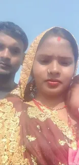 Family in traditional attire under clear blue sky.