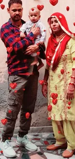 Family portrait in traditional attire against a beige wall.