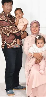 Family portrait with pastel attire and rustic vase decor.