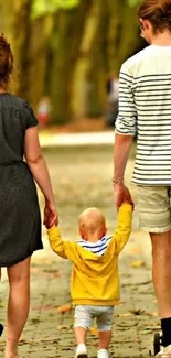 Family walking in park under tree canopy.