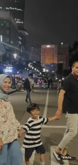 Family walking in a city at night with streetlights.