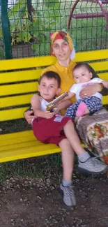 Family sitting on a yellow park bench, enjoying outdoor time.