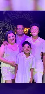 Family smiling under a purple night sky.