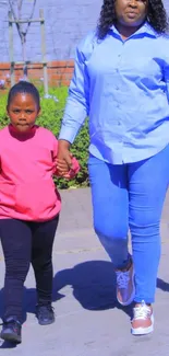 Mother and daughter walking hand in hand on a sunny day.